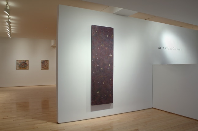 Photograph showing a view of an exhibition space, with three paintings hanging on white walls