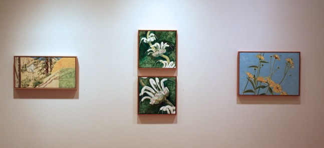 Photograph showing a view of an exhibition, with four small framed paintings hanging on a white wall