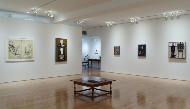 Photograph showing a corner view of an exhibition space, with five paintings hung on white walls