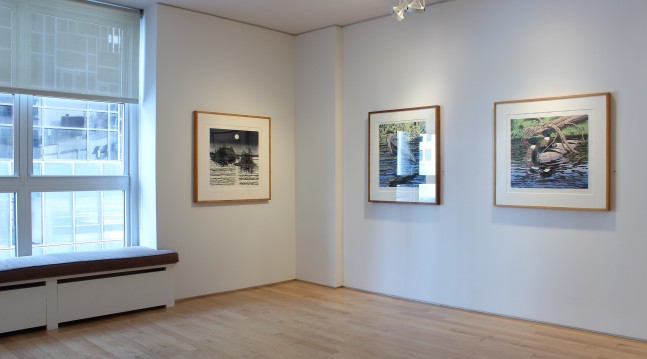 Photograph showing a corner view of an exhibition space, with three paintings hanging on white walls