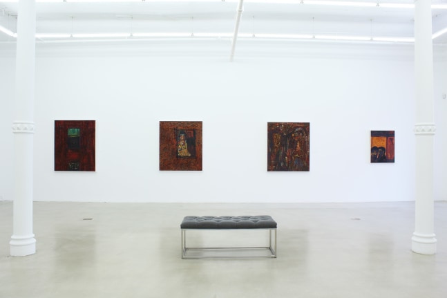 Photograph showing a view of an exhibition space, with four paintings hanging on a white wall