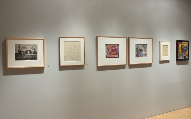 Photograph showing a view of an exhibition space with six framed drawings hanging on a wall