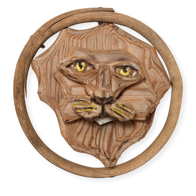 Wall-hanging, partially-painted wood sculpture of the head of a lion inside a wooden hoop