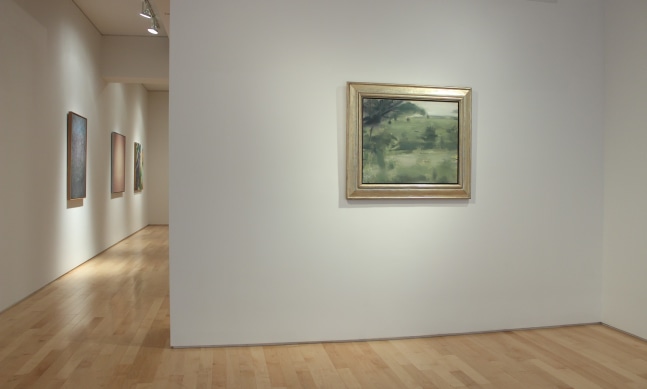 Photograph showing a view of an exhibition space with one painting hanging on a white wall