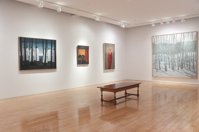 Photograph showing a corner view of an exhibition space with four paintings hanging on white walls