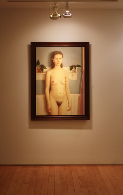 Photograph showing a view of an exhibition, with one framed painting hanging on the wall