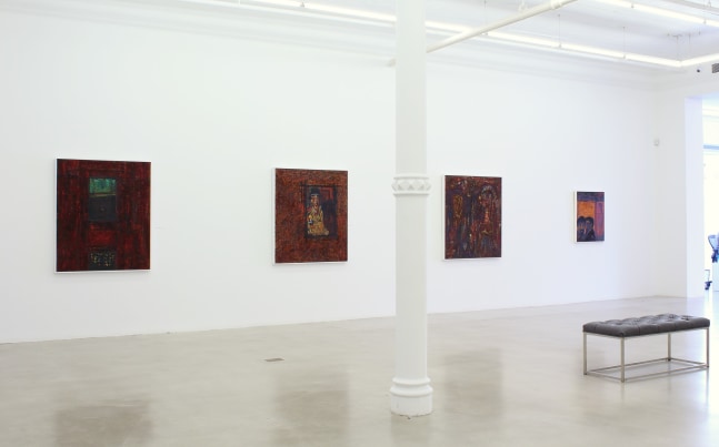 Photograph showing a view of an exhibition space, with four paintings hanging on a white wall