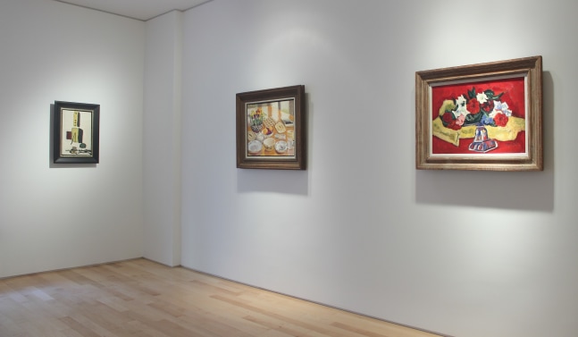 Photograph showing a corner view of an exhibition space with three paintings hanging on white walls