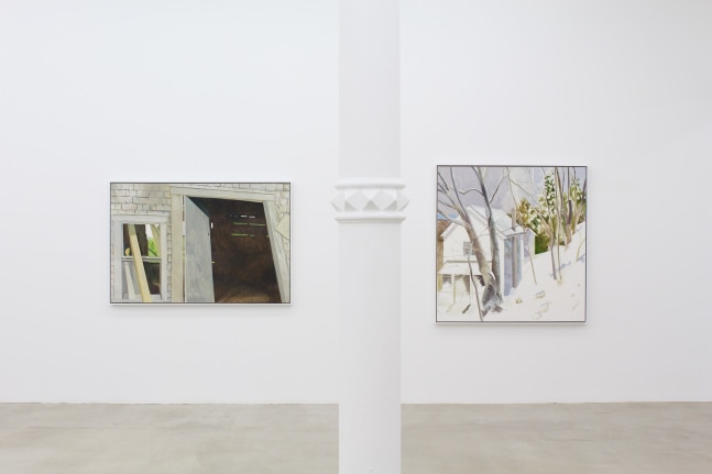 Photograph showing a view of an exhibition space, with two paintings hanging on a white wall
