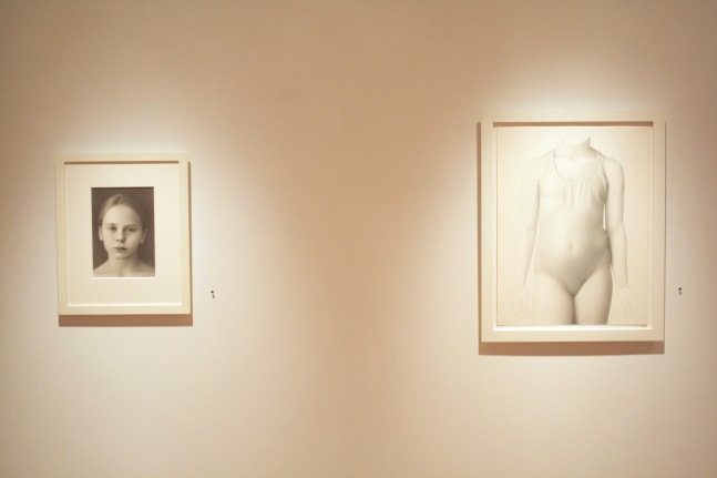 Photograph showing a view of an exhibition space, with two small framed drawings hanging on a white wall