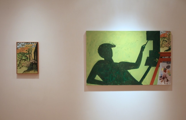 Photograph showing a view of an exhibition, with two small framed paintings hanging on a white wall