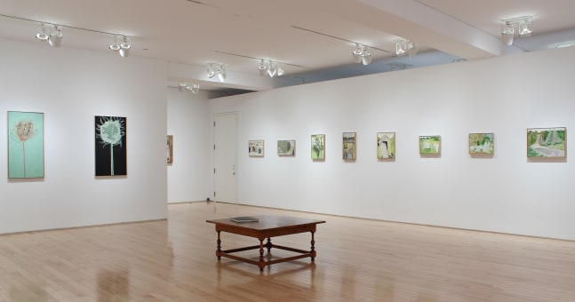 Photograph showing a corner view of an exhibition space, with ten paintings hanging on white walls