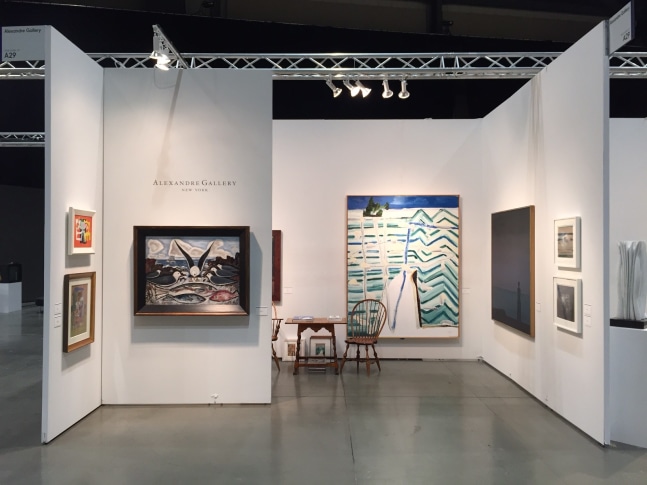 Photograph showing a view of an exhibition space, with seven paintings of various sizes hanging on white walls