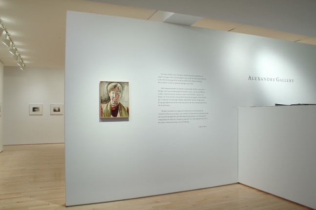 Photograph showing a front view of an exhibition space, with one painting hung on a white wall beside a block of wall text
