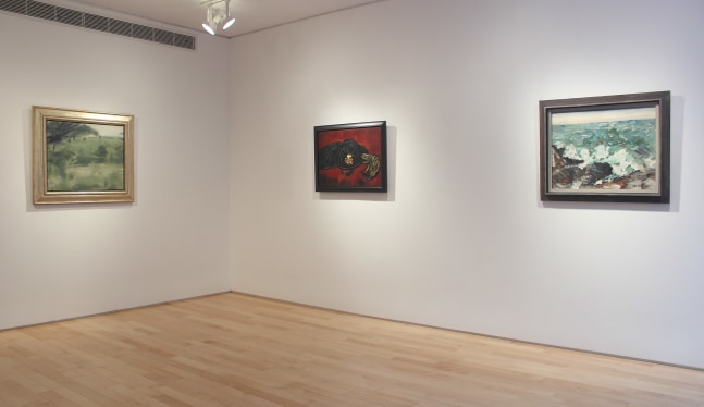 Photograph showing a corner view of an exhibition space with three paintings hanging on white walls
