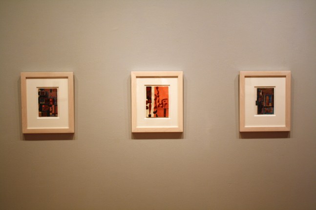 Photograph showing a view of an exhibition, with two small framed drawings hanging on a grey wall