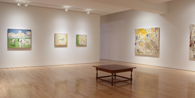 Photograph showing a corner view of an exhibition space, with four paintings hanging on white walls