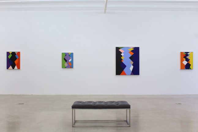 Photograph showing a view of an exhibition space, with four paintings hanging on a white wall