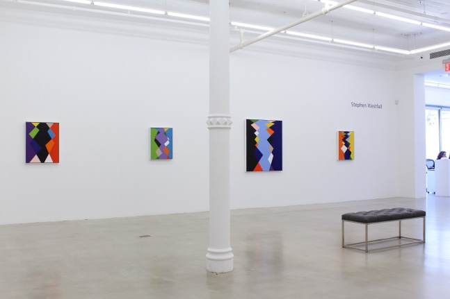 Photograph showing a view of an exhibition space, with four paintings hanging on a white wall