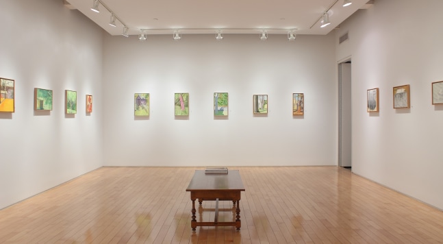 Photograph showing a view of an exhibition space with eleven small paintings hanging on white walls