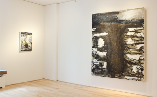 Photograph showing a corner view of an exhibition space, with one large painting and one small painting hanging on white walls