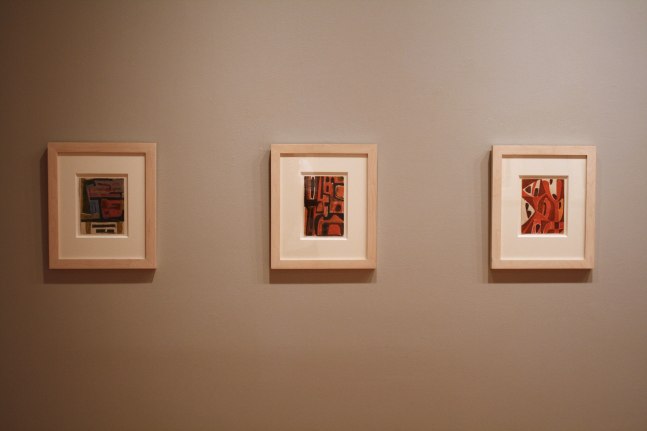 Photograph showing a view of an exhibition, with two small framed drawings hanging on a grey wall