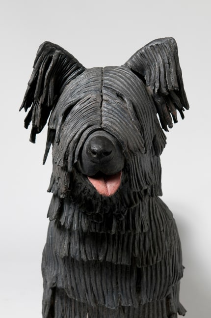 Detail view of a sculpture of a small, shaggy dog