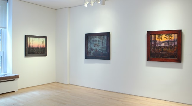 Photograph showing a corner view of an exhibition space, with three paintings hanging on white walls