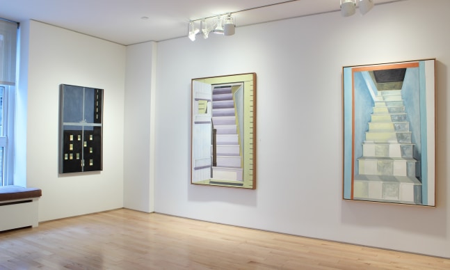 Photograph showing a corner view of an exhibition space, with three paintings hanging on white walls