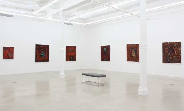 Photograph showing a corner view of an exhibition space, with six paintings hanging on white walls