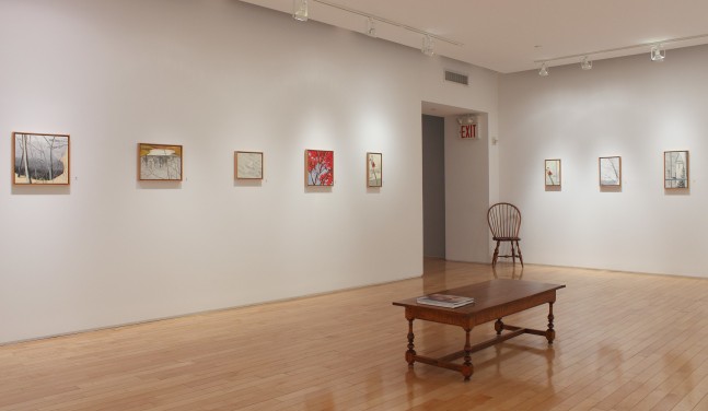 Photograph showing a corner view of an exhibition space with eight small paintings hanging on white walls