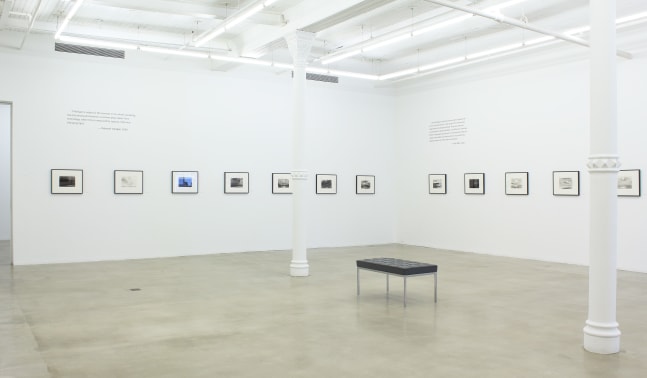 Photograph of twelve framed drawings in a white gallery exhibition space