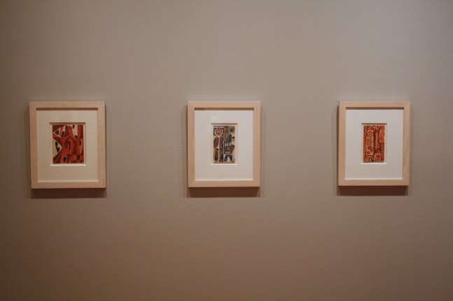 Photograph showing a view of an exhibition, with two small framed drawings hanging on a grey wall