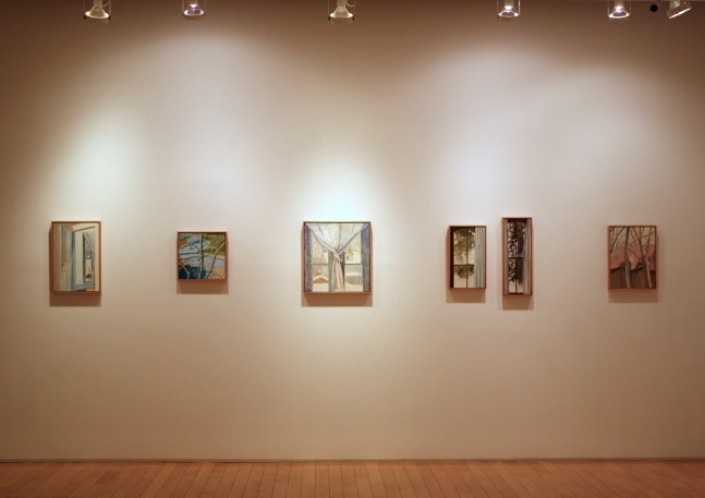 Photograph showing a view of an exhibition space, with six small framed paintings hanging on a white wall
