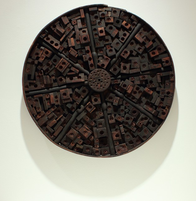 Photograph showing a round sculpture constructed from pieces of wood and metal