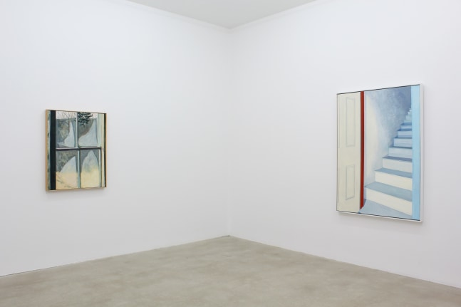 Photograph showing a corner view of an exhibition space, with two paintings hung on white walls