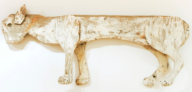 Wall-hanging wood sculpture of an abstracted cat