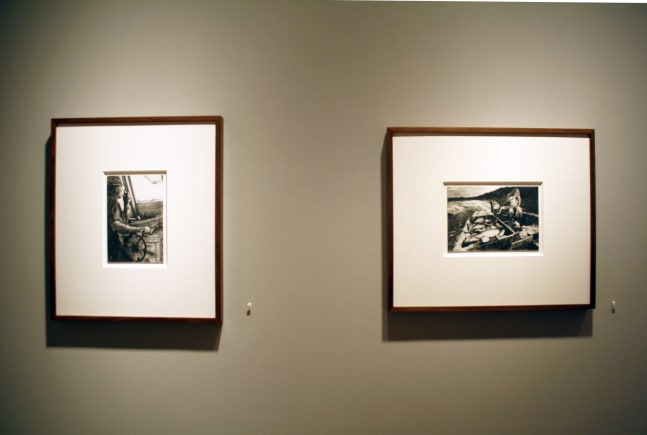 Photograph showing a view of an exhibition, with two small framed drawings hanging on a grey wall