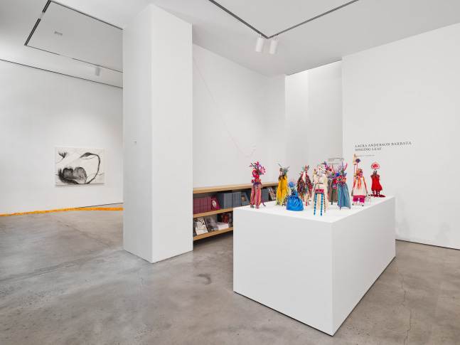 Installation view of &quot;Laura Anderson Barbata: Singing Leaf&quot; showcasing small 'alebrije' figurines on stilts.