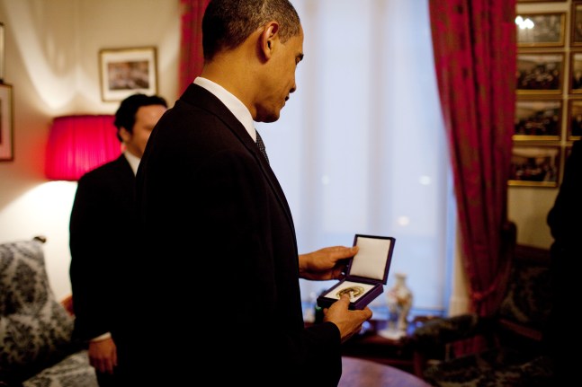 President Obama looks at his Nobel Peace Prize medal, Oslo, Norway, December 10, 2009 (Courtesy Barack Obama Presidential Library)
