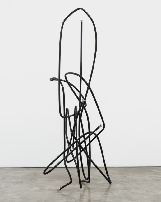A freestanding sculpture by Josh Callaghan of black metal tubing arched and interlocking.
