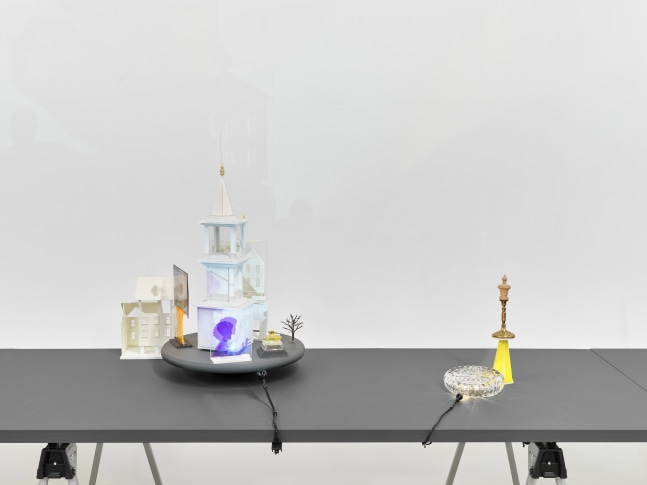 A series of assemblage sculptures comprised of upside down crystal vases, miniature street lamps, photographs printed on plexiglass and steeples made from styrene atop rotating platforms.