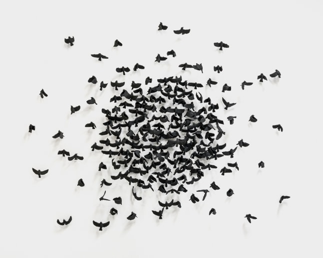 A wall mounted sculpture by Camilla Taylor of 281 ceramic black sparrows.