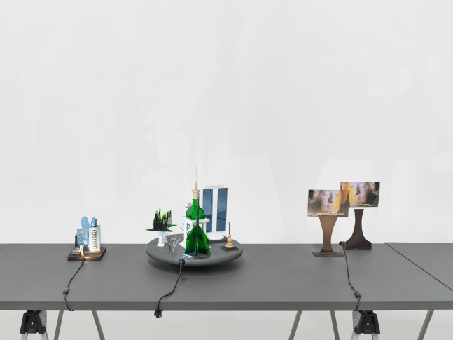 A series of assemblage sculptures comprised of upside down crystal vases, miniature street lamps, photographs printed on plexiglass and steeples made from styrene atop rotating platforms.