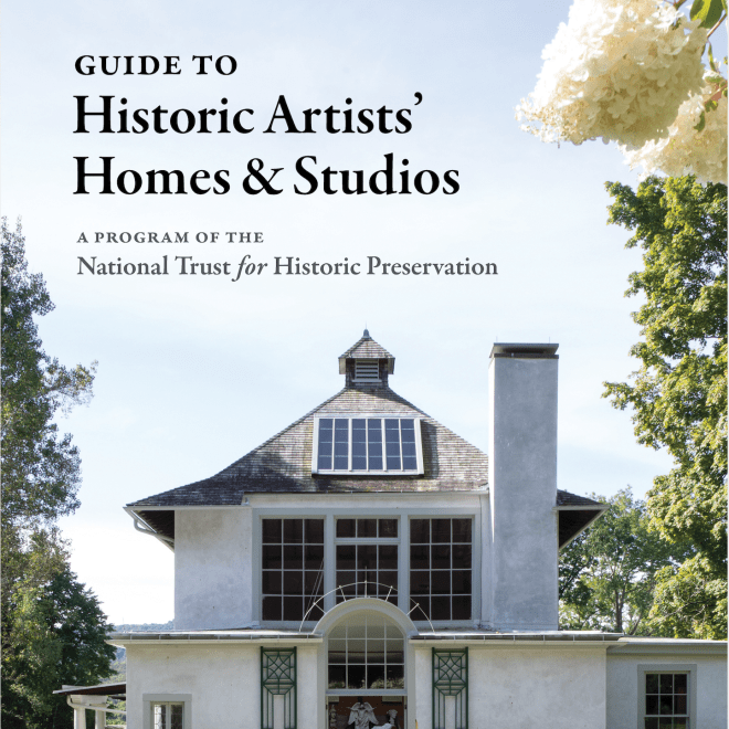 Photo of a large, white, mediterranean style house with big dark windows on the second floor. Above the house the sky is a pale blue and there is black, ornate lettering, "Guide To Historic Artists' Homes & Studios A Program of the National Trust for Historic Preservation. On the top right of the frame there is a couple of large, fluffy looking, white flowers. 