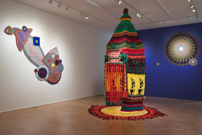 An installation view of &ldquo;Xenobia Bailey: Paradise Under Reconstruction in the Aesthetic of Funk: The Second Coming.&quot; On the floor is the show&rsquo;s centerpiece, &ldquo;Sistah Paradise&rsquo;s Great Walls of Fire Revival Tent.&rdquo;Credit...via Xenobia Bailey and Venus Over Manhattan, New York