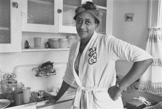 Woman in her kitchen with rollers in her hair, Detroit, 1968