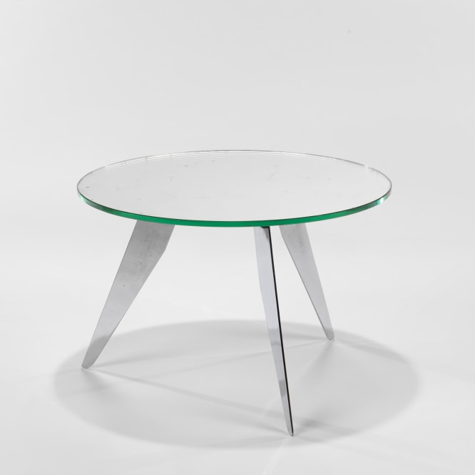 photograph of table in a blank room with steel legs and a mirror top
