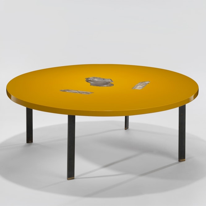 low yellow table with black legs in an empty room