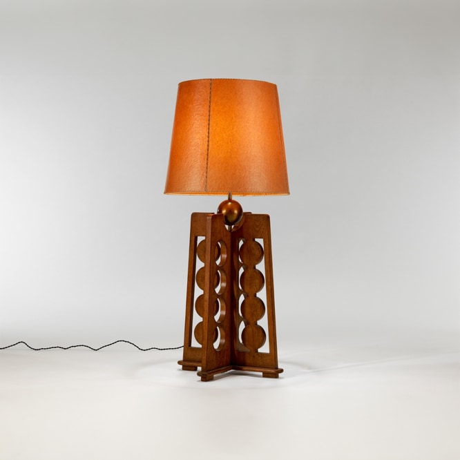picture of a lamp with a wood base in a grey room